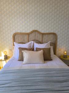 een slaapkamer met een bed met witte lakens en kussens bij Meloneras Garden Bungalow in Meloneras
