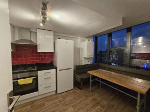 a kitchen with white appliances and a wooden table at Penthouse - Whitechapel in London +103 photos