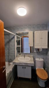 a bathroom with a sink and a toilet and a mirror at NIMBO Apartment in Sierra Nevada +24 photos