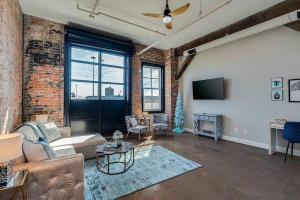 a living room with a couch and a tv at Breakfast at Tiffanys Downtown Newport News in Hampton