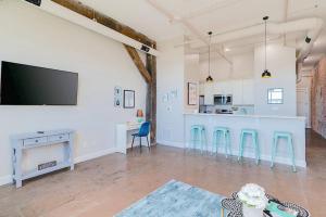 a large room with a kitchen and a bar with stools at Breakfast at Tiffanys Downtown Newport News in Hampton