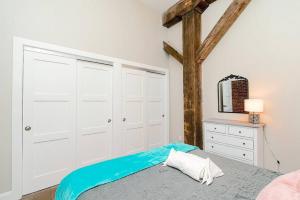 a bedroom with white cabinets and a bed and a mirror at Breakfast at Tiffanys Downtown Newport News in Hampton