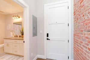 a white door in a bathroom with a brick wall at Breakfast at Tiffanys Downtown Newport News in Hampton +14 photos