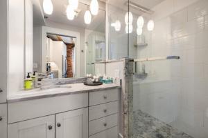a white bathroom with a sink and a shower at Tugboat Vista 2 Bedroom Downtown Portsmouth in Portsmouth +17 photos