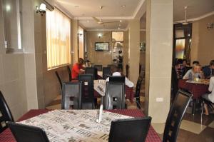 a restaurant with tables and people sitting at tables at Rich Hotel in Arusha