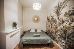 a bedroom with a bed in a room with a mural at Maison avec jardin - Centre ville de Cambrai in Cambrai
