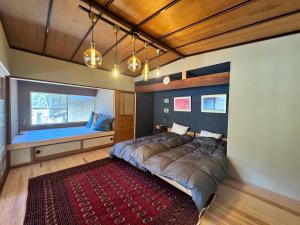 a bedroom with a large bed and a window at KUMANOYASAI Cottage in Chikatsuyu in Tanabe
