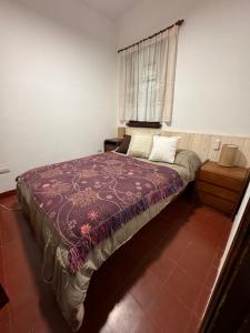 a bedroom with a large bed with a window at La Escondida de la Aldea Serrana in Valle Hermoso