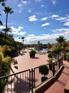 een patio met palmbomen en een hek bij Meloneras Garden Bungalow in Meloneras