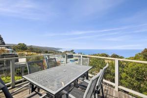 una mesa y sillas en una terraza con vistas al océano en View from the Hill, en Lorne