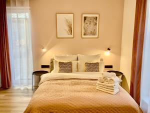 a bedroom with a large bed with two pictures on the wall at Salt Garden Apartments in Druskininkai