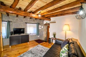 a living room with a couch and a tv at Casa Ribeiro in Sabugueiro