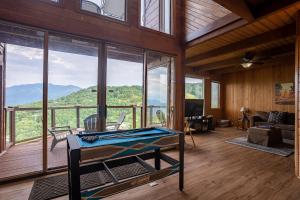 ガトリンバーグにあるBeautiful 4 bedroom chalet with million dollar viewsのリビングルーム(窓の前にビリヤード台付)