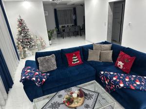 a blue couch in a living room with a christmas tree at Tatrzański Domek & SPA in Poronin