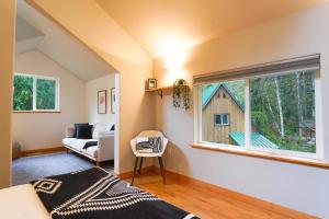 ein Schlafzimmer mit einem Bett und ein Fenster mit einer Scheune in der Unterkunft Colfax Cabin in Glacier