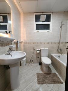 un bagno con lavandino, WC e vasca di TheGrid-HomeStay a Abu Dhabi Altre 5 foto