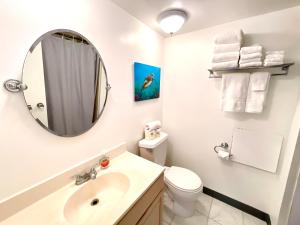 a white bathroom with a sink and a mirror at Marine Surf 20FL Free Parking Renovated - Cal King in Honolulu +10 photos