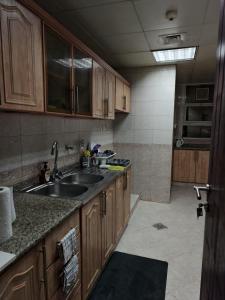 una cucina con mobili in legno e un lavello di TheGrid-HomeStay a Abu Dhabi