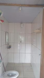 a white bathroom with a shower and a toilet at Camping rock in Itanhaém