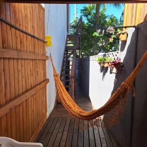 a hammock hanging on a porch with a staircase at Apartamento na Barra de Ibiraquera in Imbituba