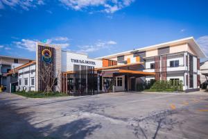 un edificio con una señal delante de él en The S.G Hotel, en Buriram