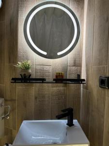 a bathroom with a sink and a large mirror at Igloo glamping dome Sarajevo in Sarajevo