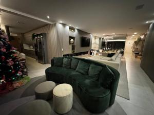 un soggiorno con divano verde e albero di Natale di Cobertura magnífica frente mar a Florianópolis