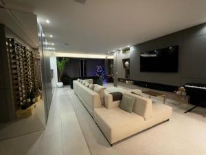 soggiorno con divano bianco e cantina di Cobertura magnífica frente mar a Florianópolis