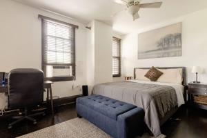 a bedroom with a bed and a desk and a chair at Sweet Home - Zoller Stays in Long Island City