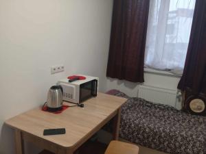 a microwave sitting on a table next to a bed at Nea Iskra Vyletska Berezhanska street in Lviv