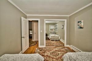 a room with two beds and a hallway with a mirror at Madison House in Skokie
