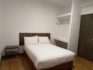 a bedroom with a large bed with a wooden headboard at Hostal Schultz in Mexico City