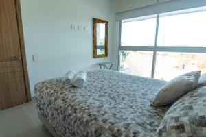 a bedroom with a bed with shoes on it at BAIA Kristal Cartagena Condo in Cartagena de Indias +16 photos