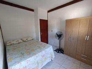 a bedroom with a bed and a closet and a fan at Casa de descanso a 4km - 5 min da Guarda do Embaú in Palhoça