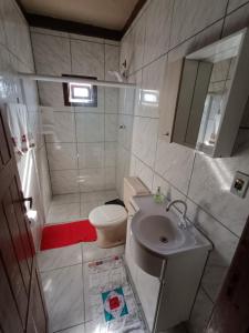 a bathroom with a shower and a toilet and a sink at Casa de descanso a 4km - 5 min da Guarda do Embaú in Palhoça