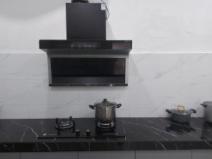 a stove top with a pot on top of it at Comfort homestay68 in Sitiawan