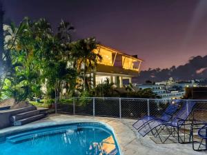 a house with a swimming pool in front of a house at Bahía 50's in Acapulco