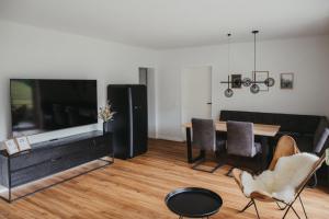 a living room with a large television and a dining table at Schwarzwald Loft Panoramablick Menzenschwand in St. Blasien