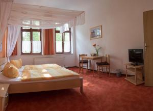 - une chambre avec un lit, une table et une télévision dans l'établissement Alte Druckerei, à Quedlinbourg