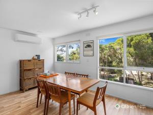 a dining room with a table and chairs and windows at Ventnor Vintage Retreat in Ventnor +9 photos