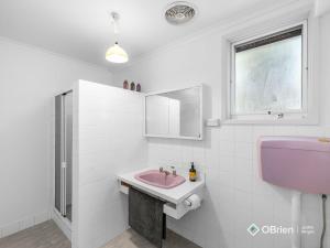 a bathroom with a pink sink and a window at Ventnor Vintage Retreat in Ventnor