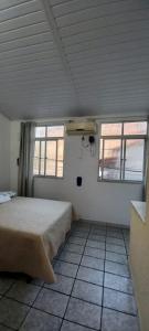 a bedroom with a bed in a room with two windows at Flat Lua Crescente - Pituba II no coração da vila caminho das praias in Itacaré +8 photos
