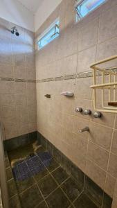 Un baño con ducha con ventana. en Casa planta alta 2 dormitorios, en Valle Hermoso