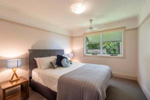 a bedroom with a large bed and a window at Clarence River Retreat - Oceanstays - Farmstay & Jetty in Lawrence