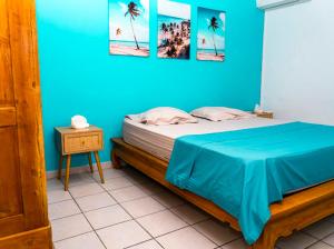 una camera da letto blu con un letto con una parete blu di Blue evasion a Les Trois-Îlets