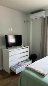 布卢梅瑙Blumen Espaço "piscina privativa'的一间卧室配有一个梳妆台,里面配有电视