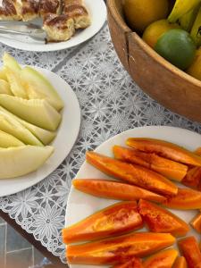 two plates of carrots and apples and a bowl of fruit at Pousada Recanto do Patrimônio in Paraty