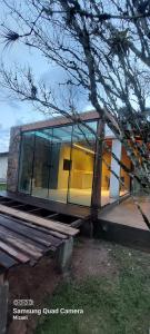 a building with glass windows and a tree at Sítio do Vô Pisco in Camboriú