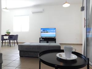 a living room with a couch and a table and a tv at Apartment Close to Beach & Private Parking in San Juan
