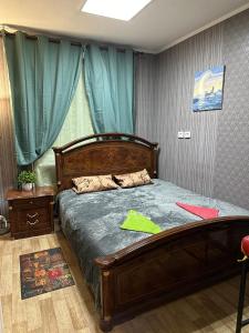 a bedroom with a wooden bed with green sheets at ArArAt-POZNYAKI Hostel KYIV in Kyiv +30 photos